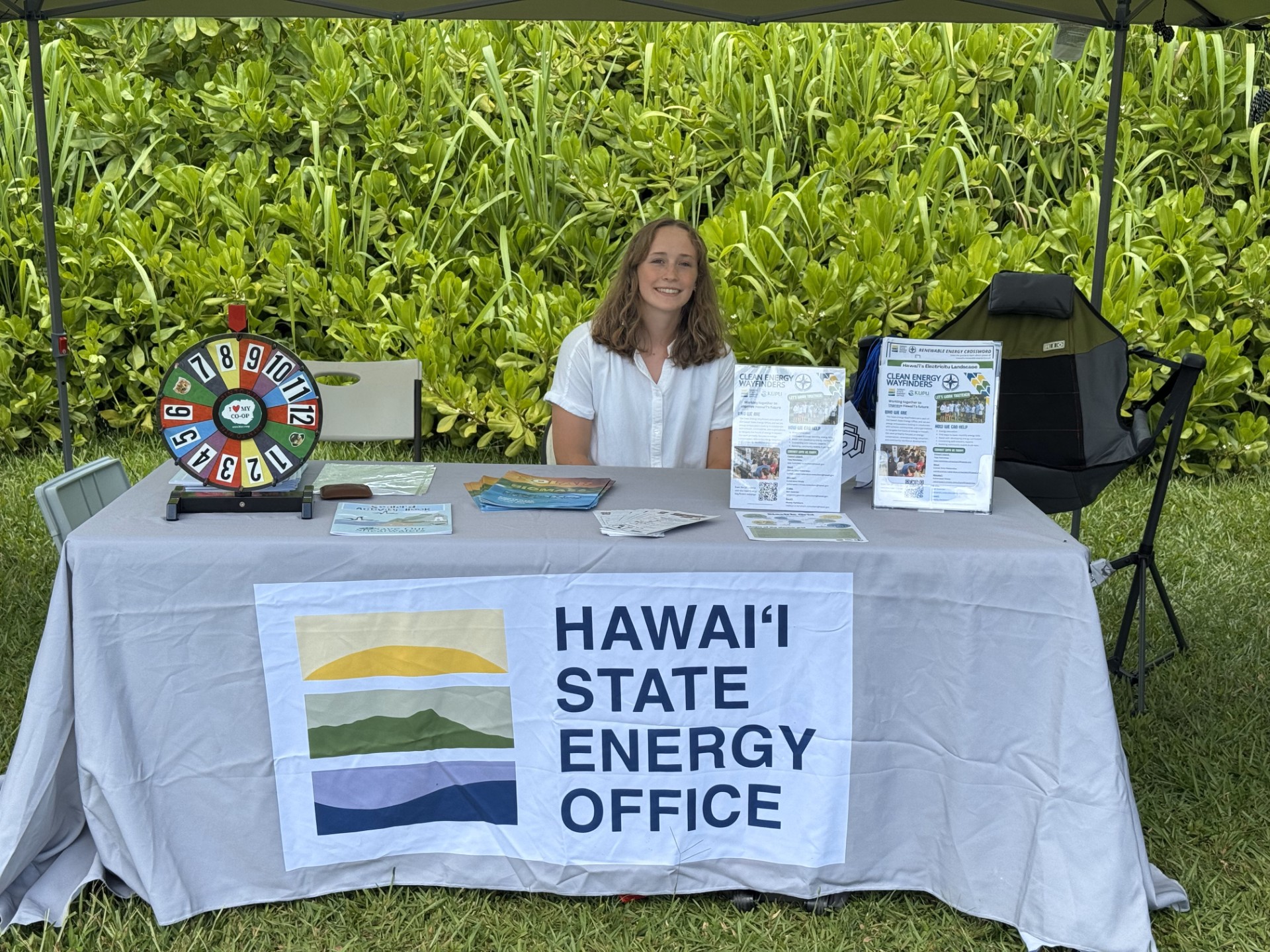 Woman smiling and sitting at a booth 