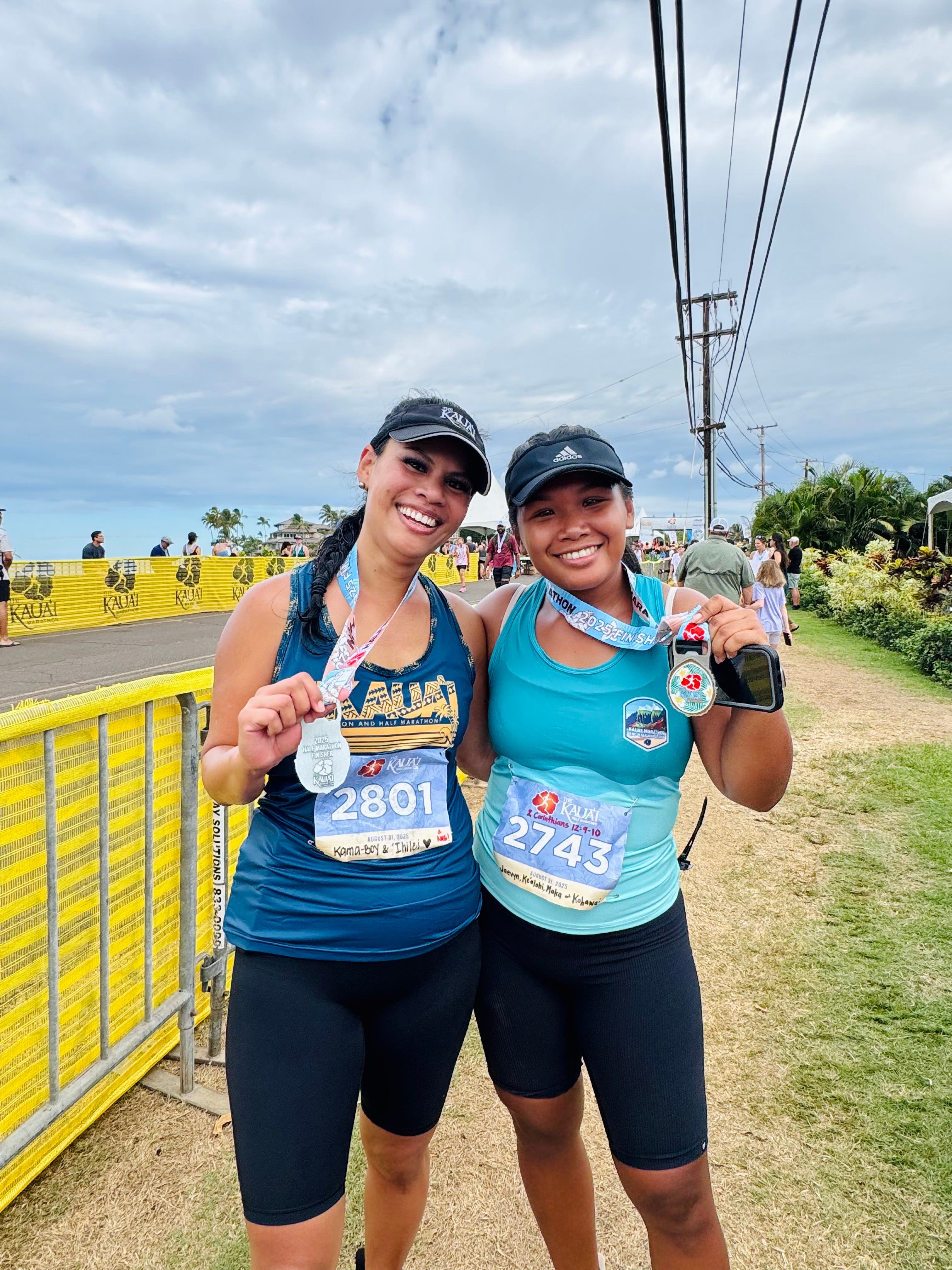2 Women smiling holding medals