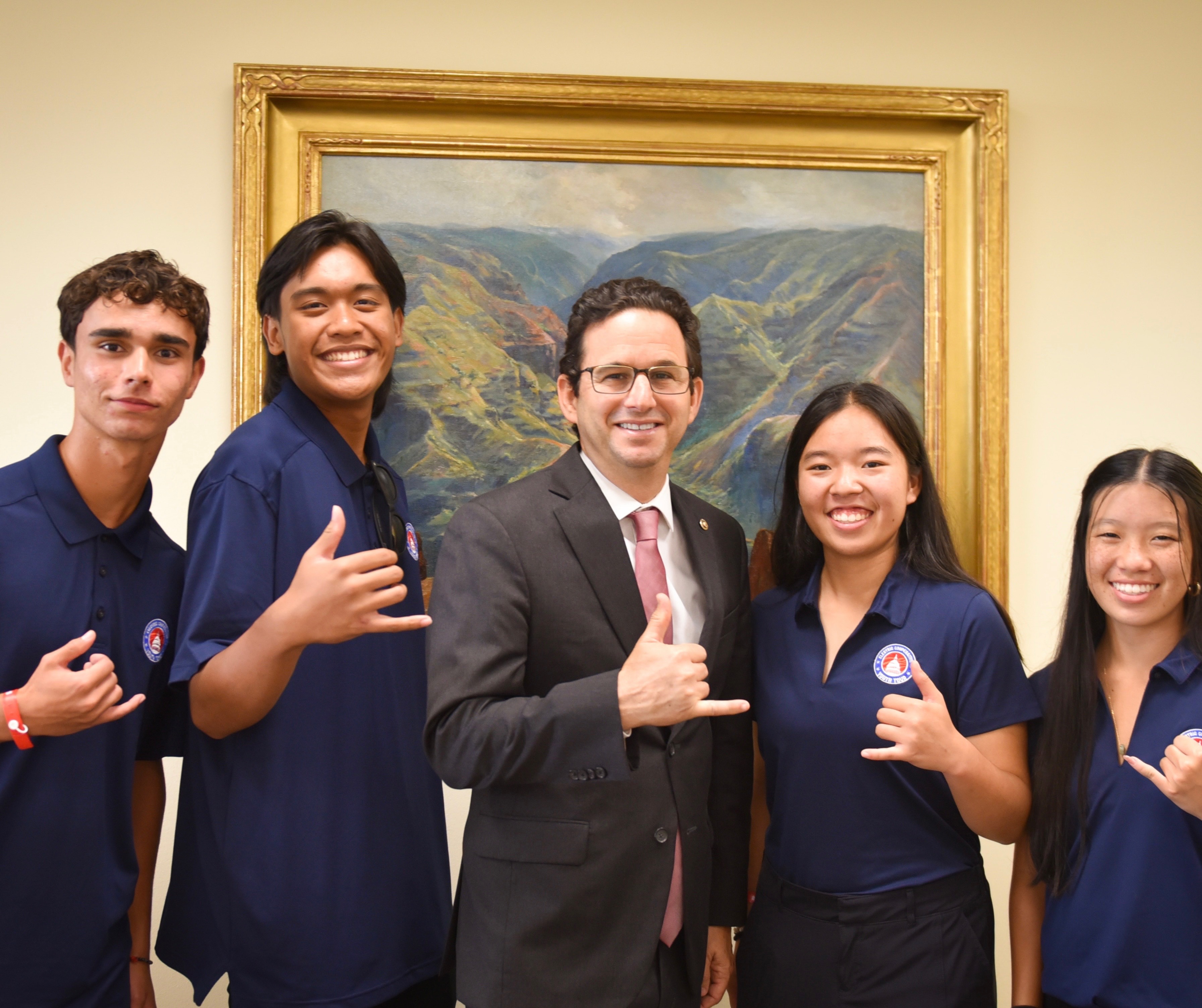 Four teenagers standing with Senator Brian Schatz with shakas