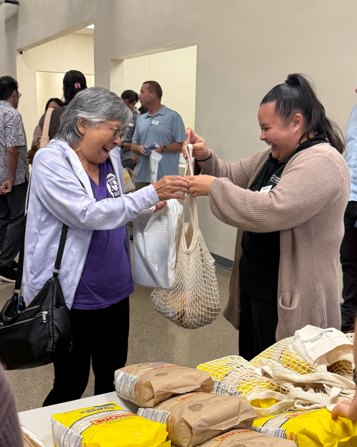 woman receiving a bag of rice at the annual meeting